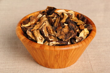 Dried mushrooms in wooden bowl. Boletus badius.