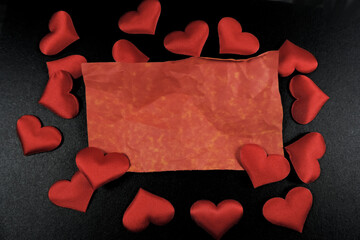 red hearts and red crumpled note with empty space for writing on black background, copy space flat lay