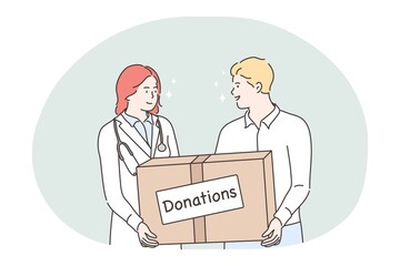 Medicine, health, volunteering, help, donation concept. Young man and woman doctor volunteers holding box with donations treatment cure from virus. Humanitarian support or red cross mission and help.
