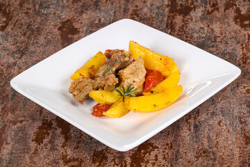 Baked pork meat with potao and tomato