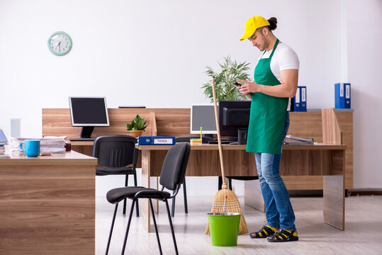 Young male contractor cleaning the office - Powered by Adobe