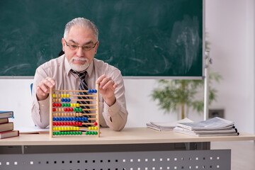 Old male teacher in the classroom