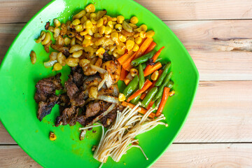 Grilled beef with vegetables in a green plate 