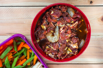 Marinated beef in a bowl and fresh vegetables