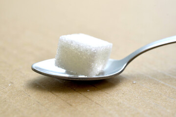 close up of sugar cubes on brown background