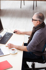 Old male employee working from house during pandemic