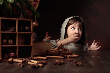 A four-year-old girl stealthily eats chocolates from the Christmas table.