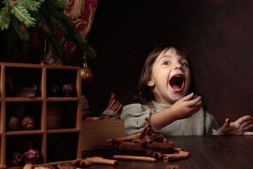Fototapeta na wymiar A four-year-old girl stealthily eats chocolates from the Christmas table.