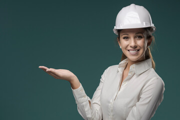 Female engineer presenting something and wearing a hardhat