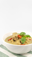 Traditional Thai cuisine, green curry chicken in white bowl over white background