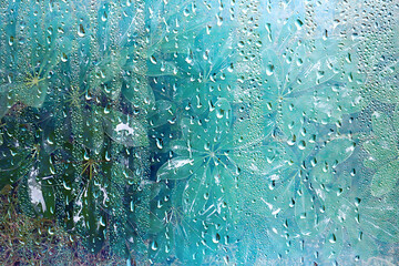 summer rain wet glass / abstract background landscape on a rainy day outside the window blurred background
