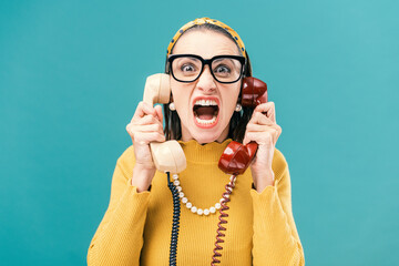 Woman holding two telephone receivers and shouting