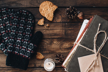 Scandinavian hygge styled Christmas composition. Cozy winter homely scene with books, cup of tea or coffee, cookies, cinnamon sticks and knitted things. Santa Claus working place. Flatlay. Home decor.