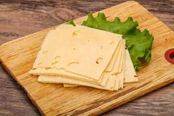 Sliced yellow cheese over board