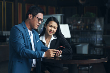 Executive business people talking and discussing with partner or colleagues in co-working space area, brainstorming and meeting team by using laptop or tablet concept