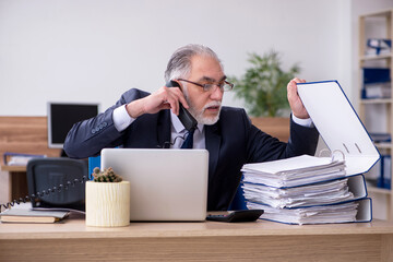 Old male employee working in the office