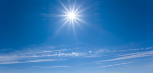 Naklejka na ściany i meble sparkle sun on a blue cloudy sky, natural sky background