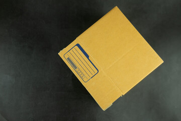 Packet of brown box with empty for write address sender on a black background