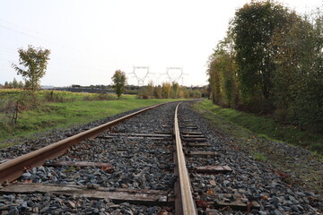 Fototapeta premium Voie de chemin de fer unique avec traverses en bois de type vignole, au milieu de la campagne en automne, ville de Saint Quentin Fallavier, département de l'Isère, France
