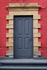 Gray front door of a red House. View of Beautiful House Exterior