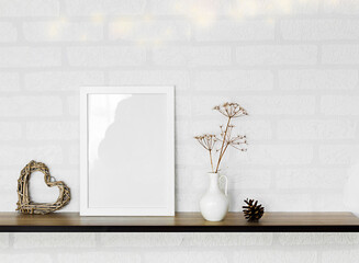 empty frame and vase of dry flowers in white wall