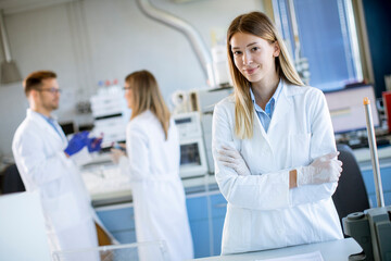 Obraz premium Female scientist in white lab coat standing in the biomedical lab