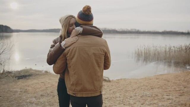 Sweet teen couple together nearby autumn lake. Love, relationship, family concept. Filmed on cinema camera. 12 bit color space.