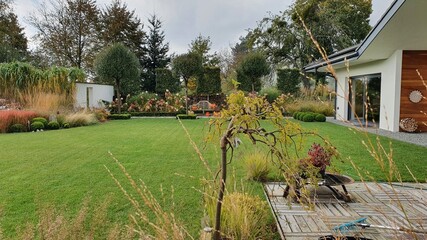 Trawnik w zadbanym nowoczesnym ogrodzie z pięknym parterowym domem