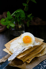 Half a chicken egg on crispy fresh thin loaves for spreading with soft cream cheese