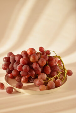 Fresh red grapes on a pastel background with shadows.Free space for text.