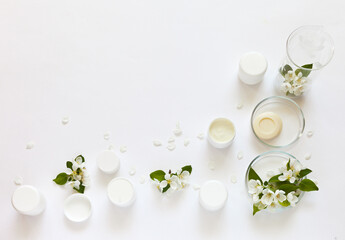 Natural cosmetics with apple extract. Jars of face and hand creams and soap on a laboratory table with chemical glassware. Creation of new types of cosmetics. Product testing. Copy space, flat lay - obrazy, fototapety, plakaty