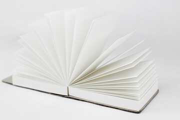 Fan open small unfold notepad with blank light beige pages. Notebook, sketchbook, book. White background