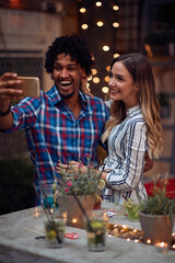 Happy couple taking a selfie at the open air birthday party. Quality friendship time together