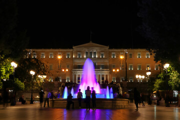 Fuente en Atenas iluminada con figuras difuminadas por el movimiento