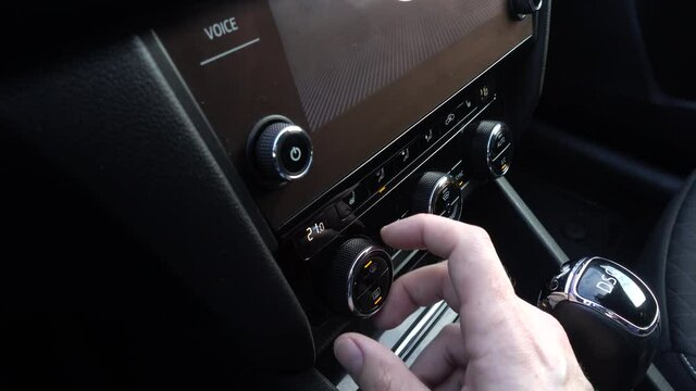Man turning on car air condition. Air conditioning systems in a car