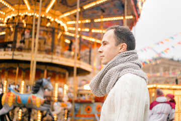 portrait of A man in winter on the street against the background of the new year's carousel on red square in Moscow