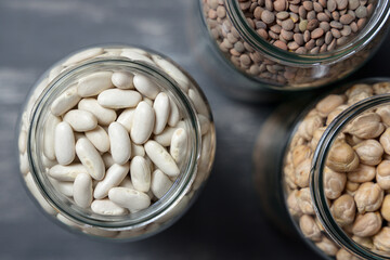 Set of glass jars with various legumes placed on a tabletop. Zero waste concept