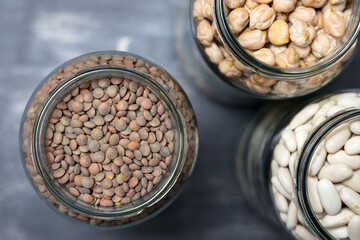 Set of glass jars with various legumes placed on a tabletop. Zero waste concept