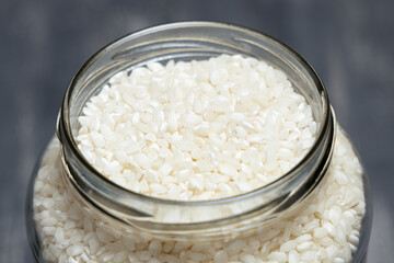 Close up of a big glass jar full of rice placed on a tabletop. Eco friendly concept
