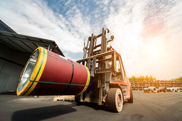 The forklift is handling big metal coil to warehouse.