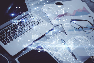 Desktop computer background in office and flying envelops hologram drawing. Double exposure. Electronic mail concept.