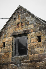 Generic old European style stone cottage wall with a small glass window.