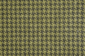 Generic yellow and black houndstooth fabric pattern texture background.