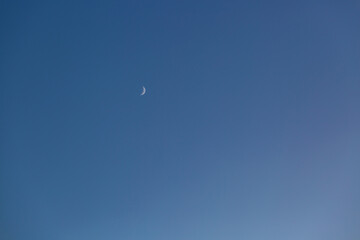 Young moon at the night sky. Background. Selective focus. Copy space for any design. 