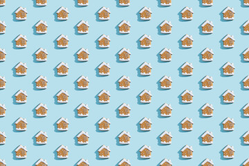 Naklejka premium Christmas bakery. Festive food pattern. Homemade cookies. Gingerbread biscuit house figures with white icing isolated on blue pastel.