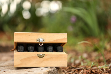 Wooden storage box full of essential oil bottles in pretty garden setting