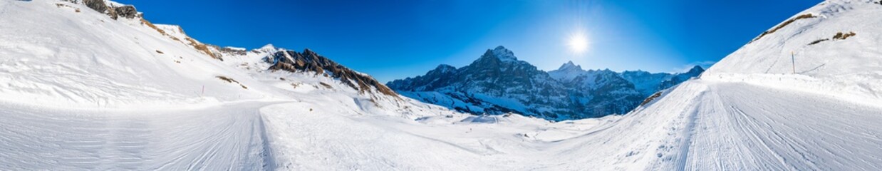 Fototapeta na wymiar 360 degree panoramic winter landscape with snow covered peaks seen from the First mountain in Swiss Alps in Grindelwald, Switzerland