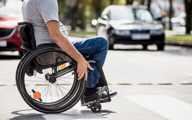 Handicapped man in wheelchair crossing street road