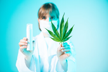 White mockup cosmetic jar with CBD product and hemp leaf in female scientist hands in neon light