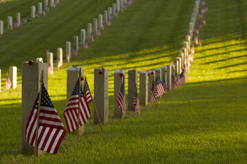 Row of veterans headstones decorated with American flags for Memorial Day remembrance